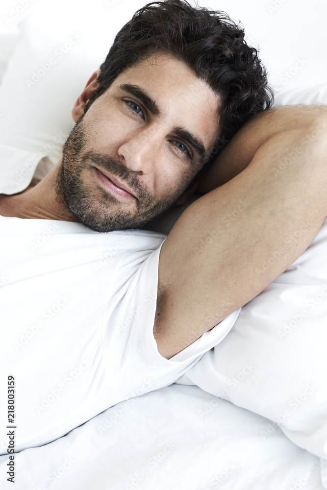 Relaxed dude in bed looking to camera Relaxed dude in bed looking to camera