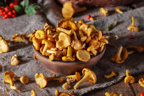 Mushrooms chanterelle in a wooden plate. Wooden background. 