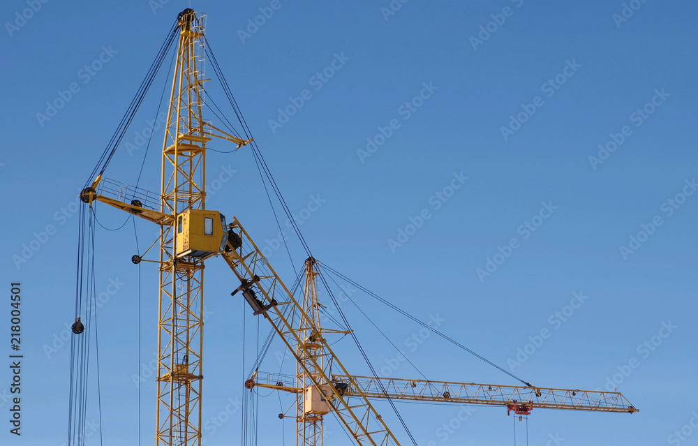 Two construction cranes against the sky background. Two construction cranes against the sky background.