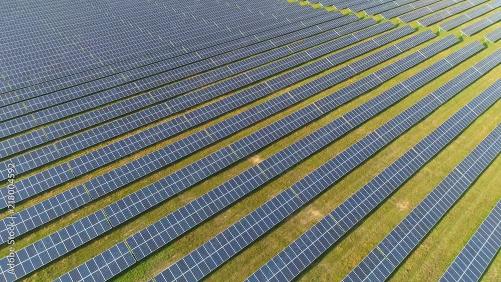 Alternative energy, view of solar panels in field from height, sunlight.
