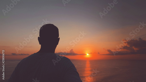 Silhouette of man in sunset / sunrise time over the ocean.