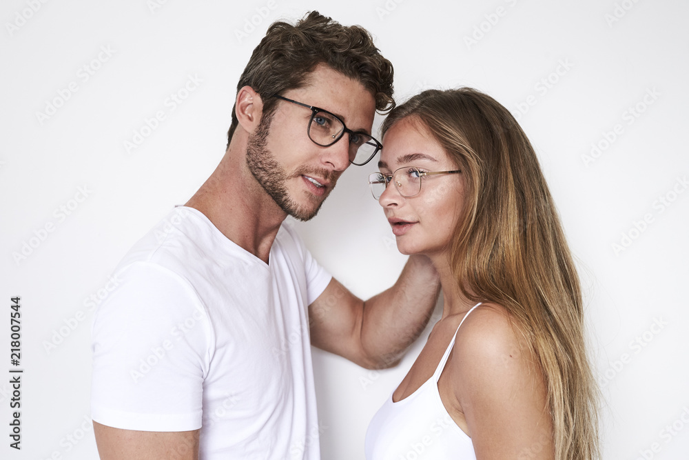 Young couple in spectacles in white studio Young couple in spectacles in white studio