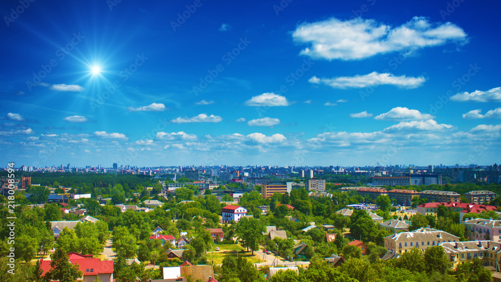 Fototapeta premium Clouds in sky above green city
