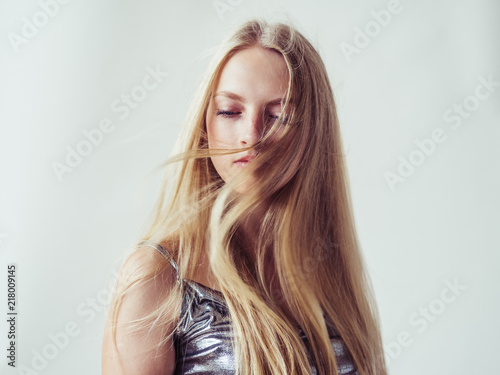 Blonde long hair woman girl in silver dress over white background