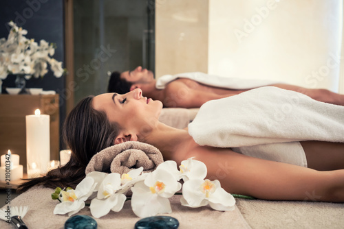 Young man and woman lying down on massage beds at Asian luxury spa and wellness center