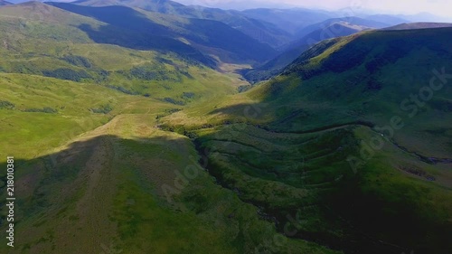 Aerial of a craggy valley covered with big cloud shadows in the Carpathians photo