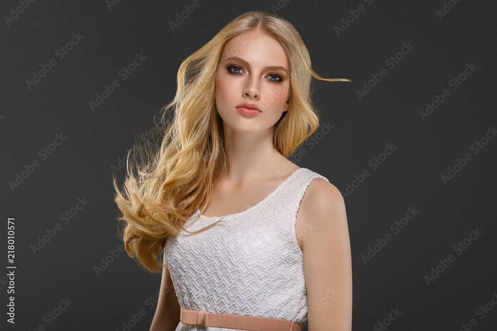 Beautiful woman with long blonde hair over gray background beauty female Beautiful woman with long blonde hair over gray background beauty female