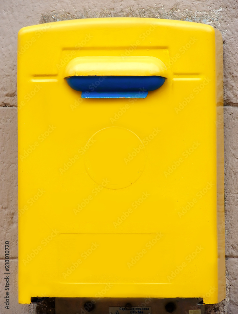 Yellow public mailbox on the wall on the wall of a building Yellow public mailbox on the wall on the wall of a building