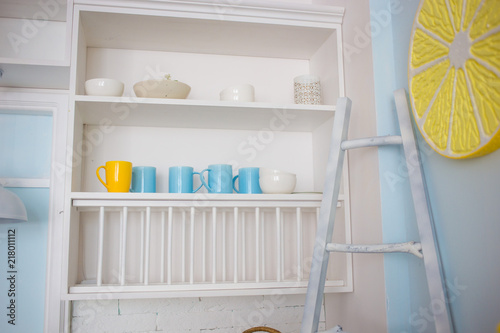 Kitchen shelf with bright cups: yellow and blue.
