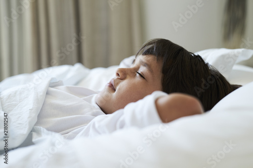 Resting boy in bed, side view