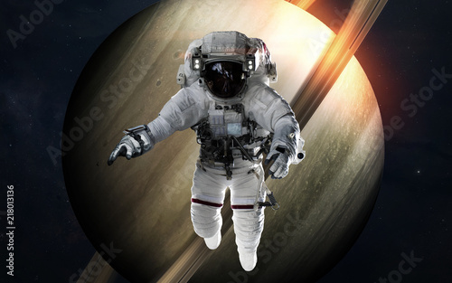 Saturn with astronaut in front of planet. Solar system. Elements of this image furnished by NASA