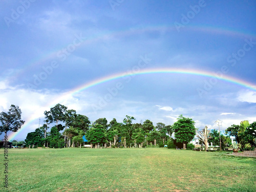 Green school turf after rain has a beautiful rainbow curve.