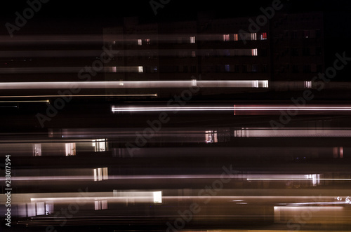 Abstract, blurry night shot of lights in windows in block building. Concept of time travelling   
