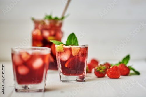 Drink. Wine. Concept. Spain. Beverage jug. Red wine sangria or punch with fruits and ice in glasses and pitcher. Homemade refreshing fruit sangria on white wooden table with copy space.