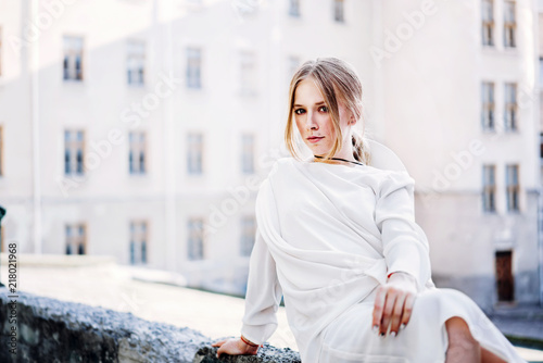 Woman in white vintage dress sitting outdoor
