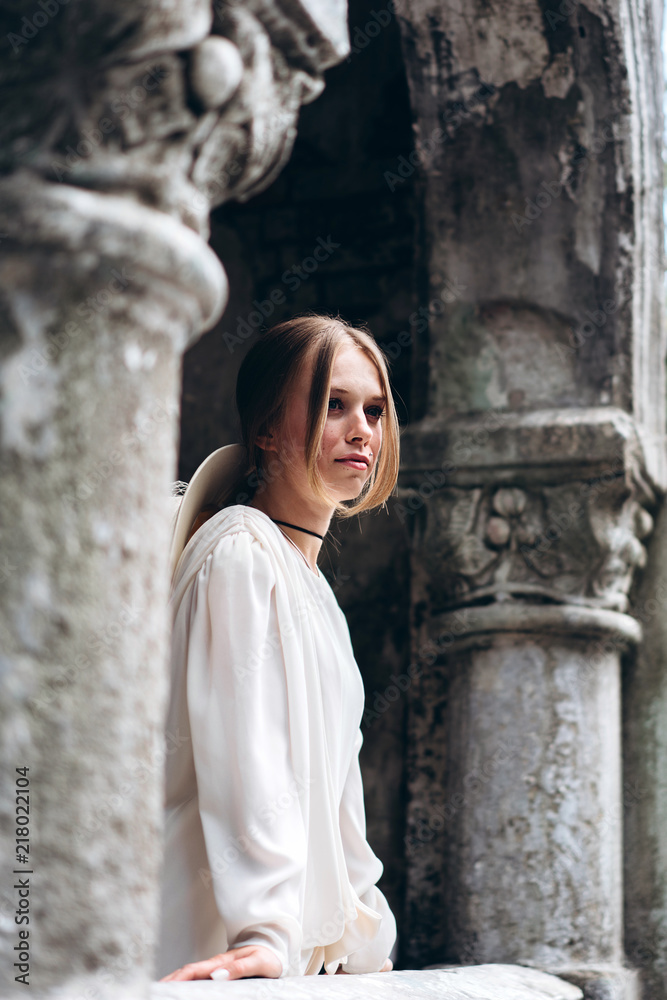 Cute woman in white dress outdoor with old building behind Cute woman in white dress outdoor with old building behind