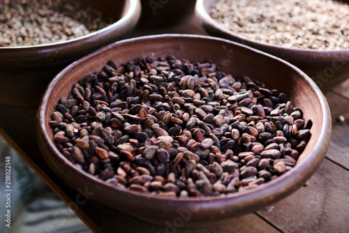 Huge rustic bowl full of coffee beans without shells. Aromatic healthy coffee beans in brown big bowl at the market.