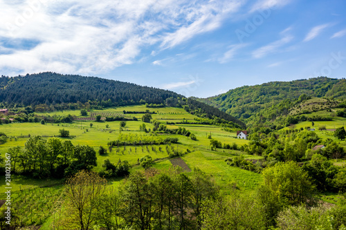 Serbian rural village green springtime landscape, mountains in Serbia are very beautiful, near Valjevo. Valley and hills. White house, farmland and spring forest in spring. European countryside