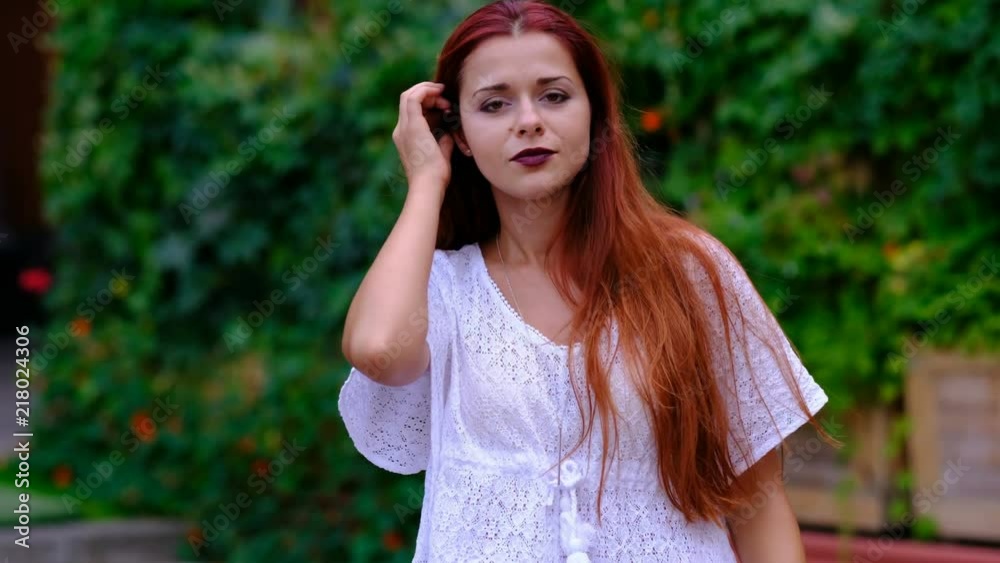 Portrait of sexy woman with long red hair, in the city. Fashion.