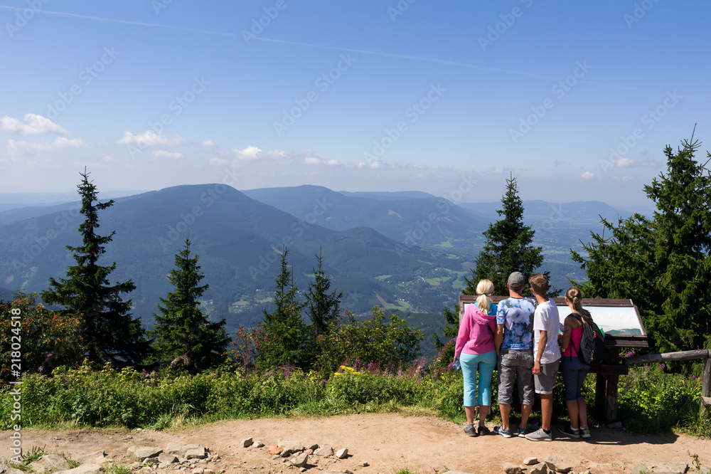 View and outlook from Lysa Hora, Beskid Mountains, Western Carpathians, Czech Republic / Czechia / Europe - young hikers and backpacers are looking from the top of the hill and mountain