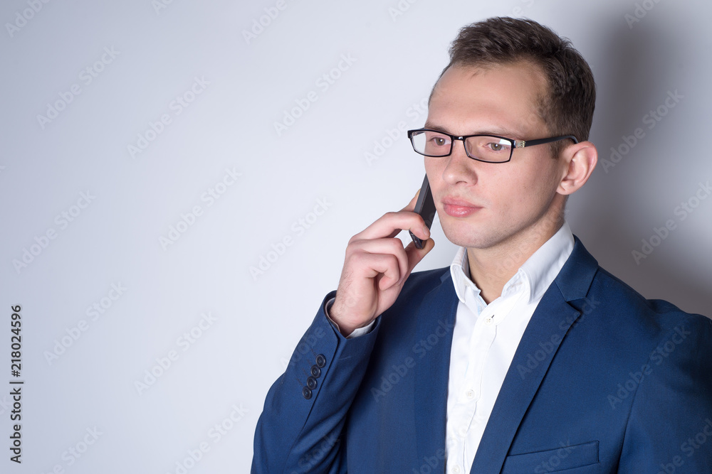 Man with phone in a blue suit on a white background Man with phone in a blue suit on a white background
