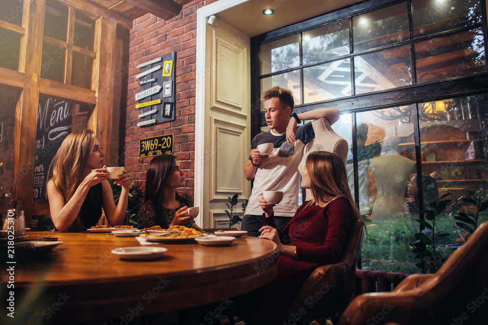 Ταπετσαρία Serious young people sitting in a fashionable cafe drinking tea discussing