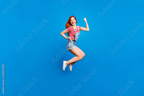 Full-size portrait of jumping happy girl who laughs and celebrat