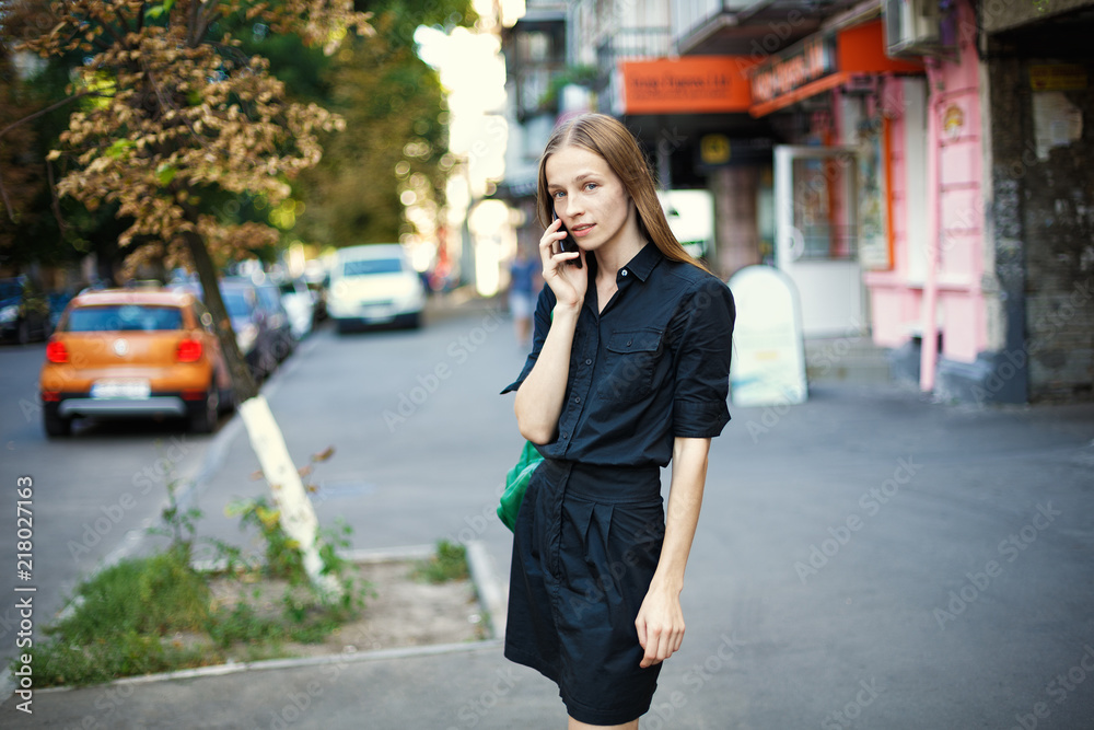 young woman with talking on mobile phone on city background