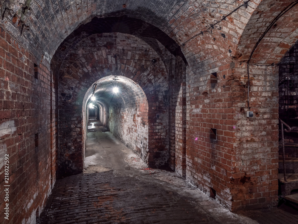 Fototapeta premium Kaliningrad, Rosja - maj 2018 r. Długi podziemny tunel prowadzący w lewo z oświetleniem.