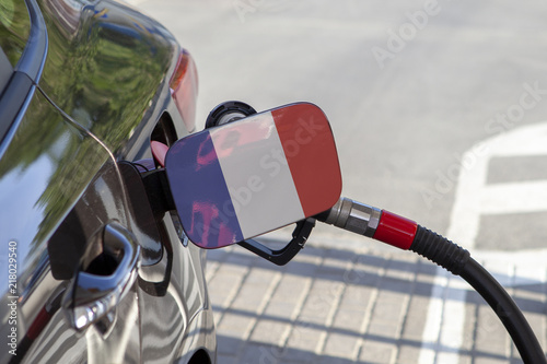 Fueling car with petrol pump at a gas station.