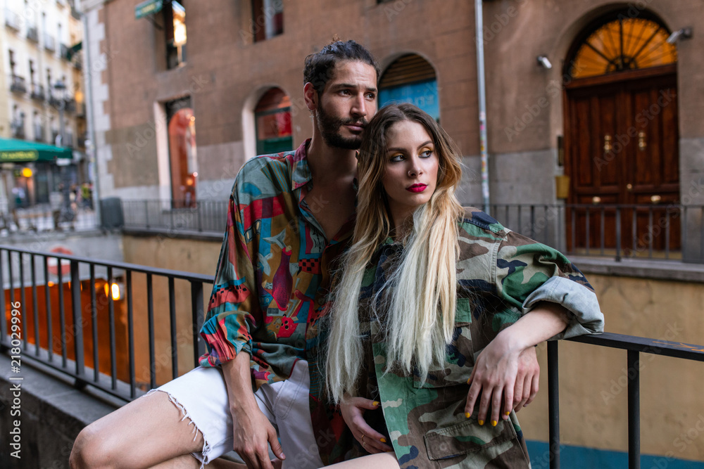 Stylish couple sitting on fence Stylish couple sitting on fence