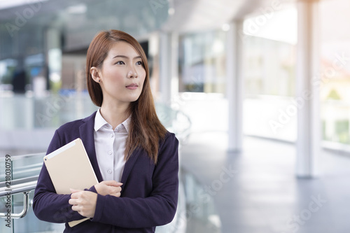 Business woman holding tablet in city with copy space
