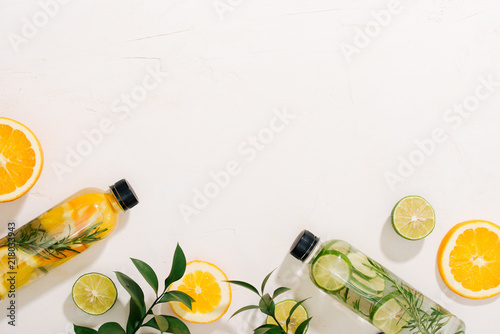 Tableau sur toile Leaves and bottle tropical water on white background