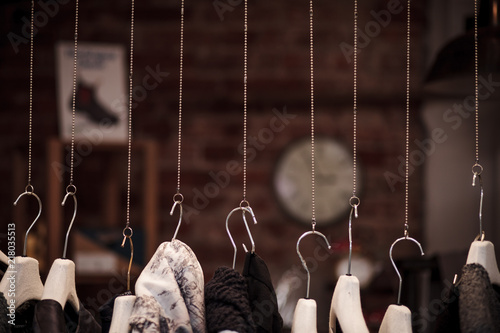 Many clothes hanger on chains with dark background in a shop photo