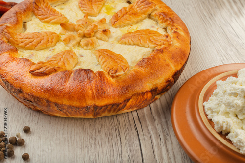 Home-made curd cake on a wooden background with ingredients.