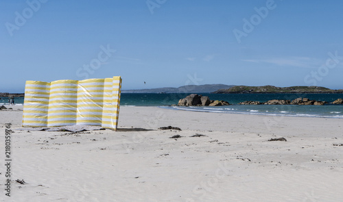 Yellow and white wind breaker on a sandy beach on a clear day. Taken in Renvyle in Ireland. photo