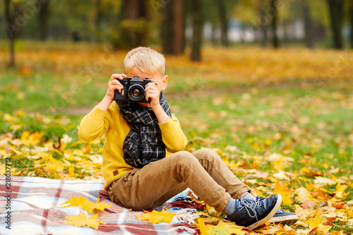 baby taking pictures, little boy taking pictures in autumn in nature photo