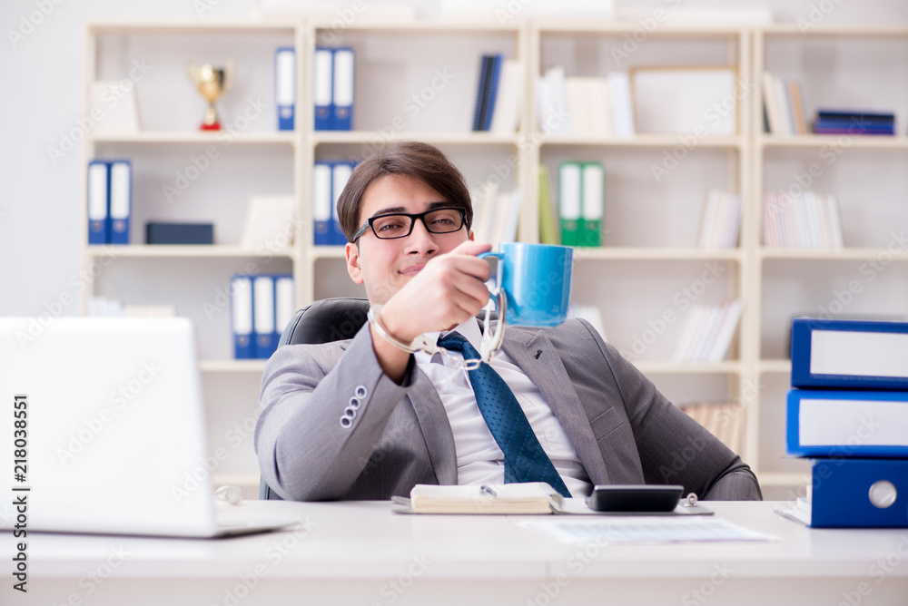 Businessman chained with handcuffs to his coffee