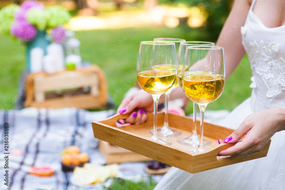 Young woman holding a dish with glasses white wine at picnic summer party, close up Young woman holding a dish with glasses white wine at picnic summer party, close up