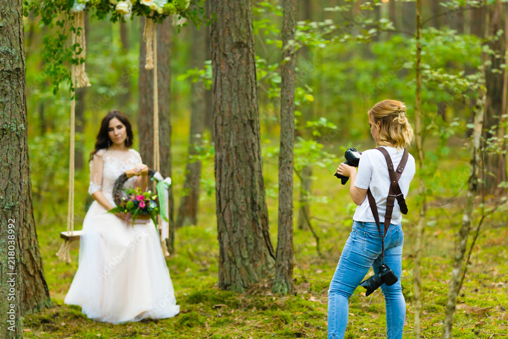 Wedding photographer taking pictures of the bride on a rope swing