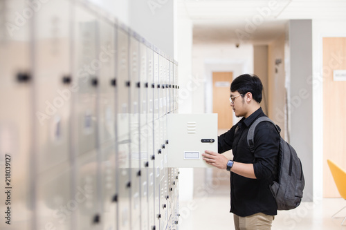 Student opening his locker at college