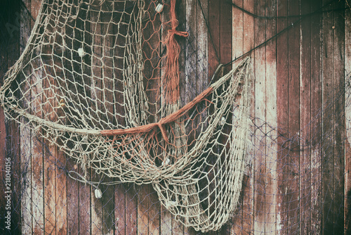  Hanging fishnet on wood wall. Background and texture for text or image. photo