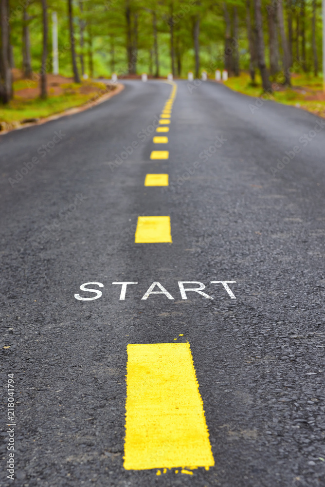 Words of start with yellow line marking on road surface in the park, transportation concept and business idea Words of start with yellow line marking on road surface in the park, transportation concept and business idea