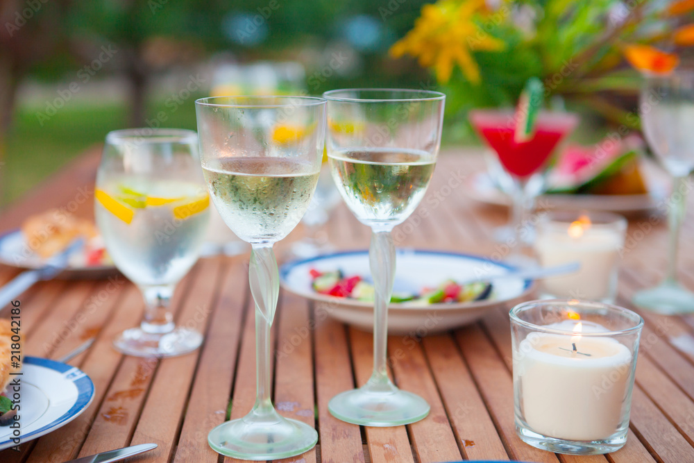 Family outdoor dinner in the garden in summer at sunset. Picnic food and drink concept