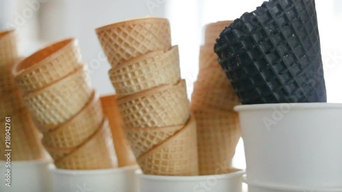 Empty fried waffle cones are stacked in each other. Real time, indoors, contour, day, close-up, camera movement from left to right