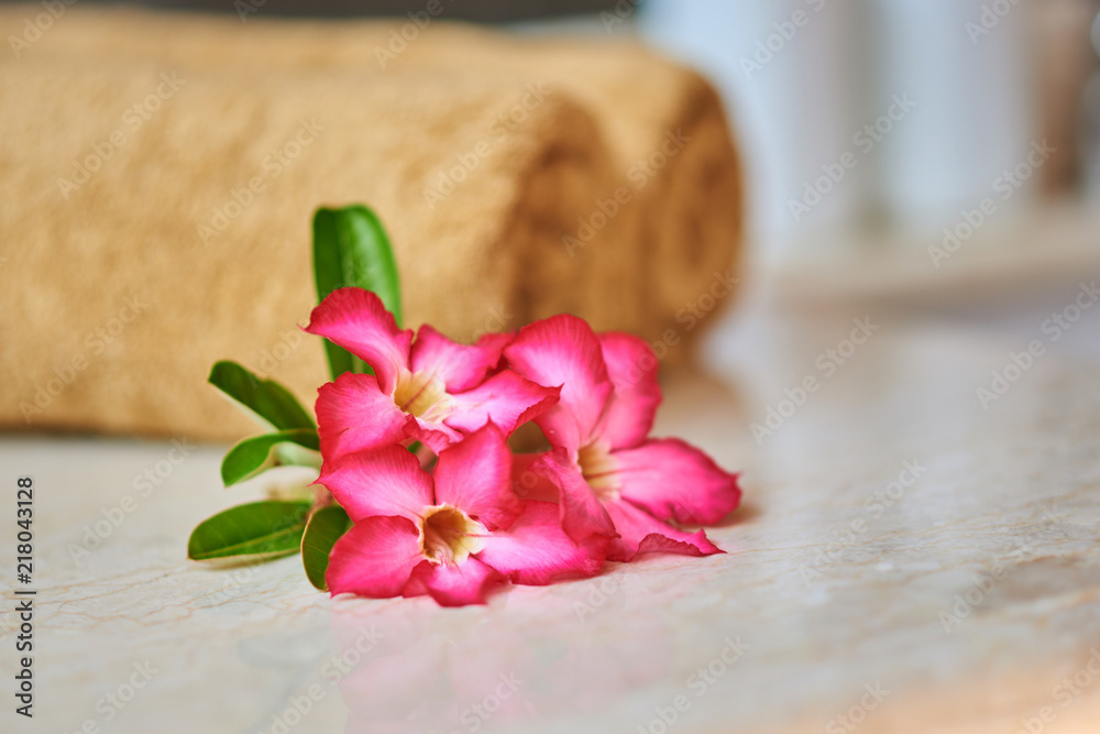 The concept of relaxation and body care. Beautiful flowers with towel and spa cosmetic.