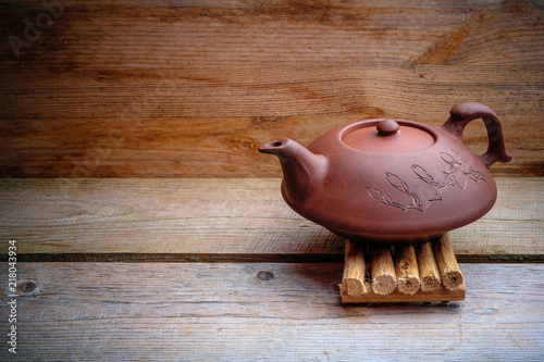 clay teapot on an old board