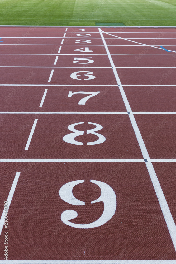 Red sport track for running on stadium with track numbers. Running healthy lifestyle concept. Sports background abstract texture