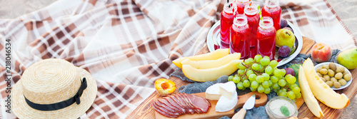 Picnic on the beach at sunset in the style of boho. Concept outdoors evening healthy dinnner with fruit and juice