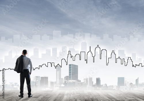 Motivation and inspiration concept with modern cityscape and businessman observing it